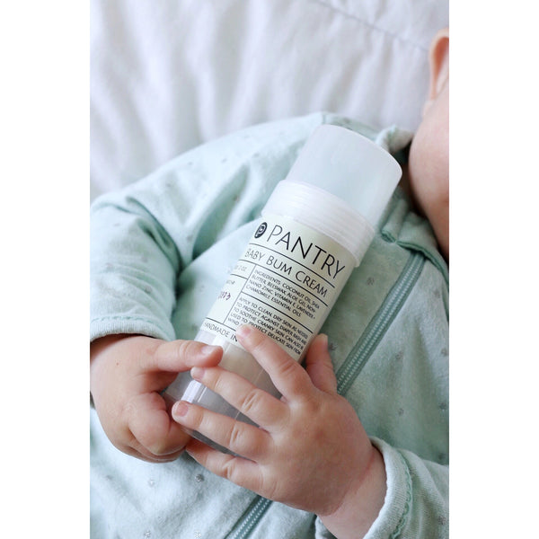 Baby Diaper Rash Cream - Healing Products - Poshinate Kiddos Baby & Kids Store - Baby holding tube of Baby Bum Cream
